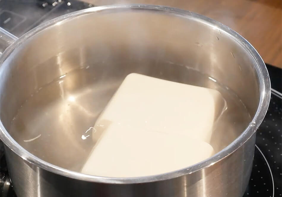 豆腐を半分に切り、2分ほど湯通しする。ざるにあげ、水気をきる